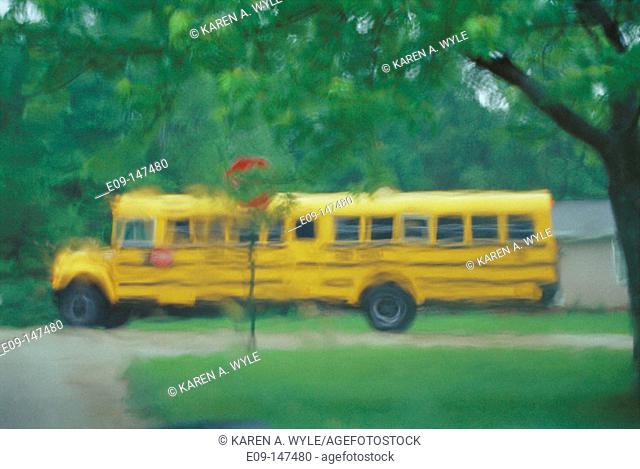 Schoolbus at neighborhood corner, seen through rainy windshield
