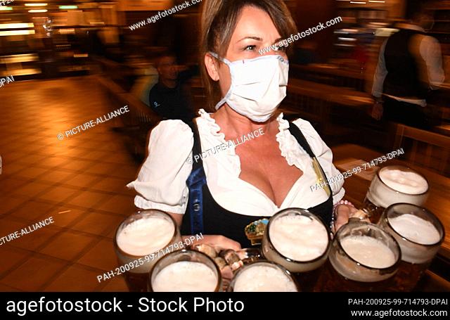 25 September 2020, Bavaria, Munich: A waitress carries six beer mugs in the Hofbräuhaus watering hole. Due to the coronavirus