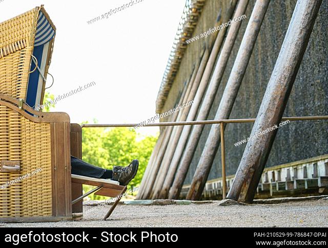 29 May 2021, Hessen, Bad Nauheim: A man has made himself comfortable in a beach chair in front of the graduation house in the spa town