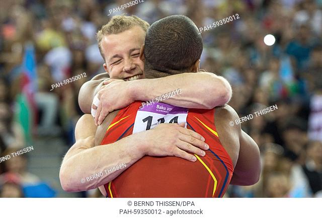 Germany's silver medal winner Fabian Hambuechen and gold medal winner Rayderley Miguel Zapata Santana of spain embrace each other after the Gymnastics Artistic...