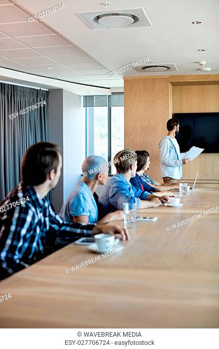 Man giving presentation to her colleagues in conference room