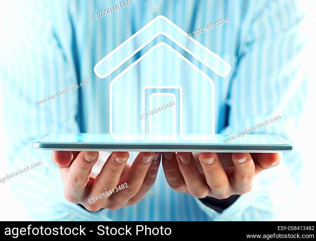 Businessman holding in hands tablet pc and home icon on screen
