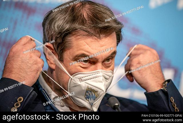 06 January 2021, Berlin: Markus Söder (CSU), Prime Minister of Bavaria and Chairman of the CSU, takes off his face mask during the press conference at the...