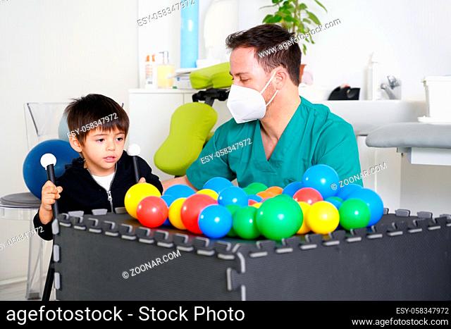 Child with cerebral palsy on physiotherapy in a children therapy center. Boy with disability doing exercises with physiotherapists in rehabitation centre