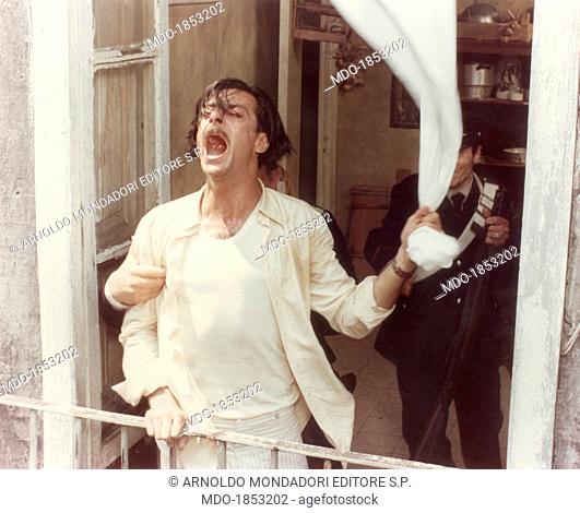 Italian actor and director Giancarlo Giannini yelling out and caughting hold of the balcony parapet with his right hand and of the tent with his left hand in...