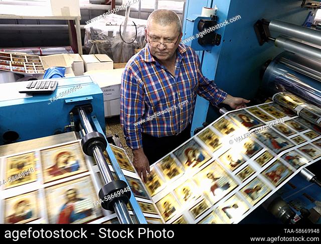 RUSSIA, MOSCOW REGION - APRIL 26, 2023: An employee works in a printing shop at the Sofrino factory of church supplies in the village of Sofrino near Moscow