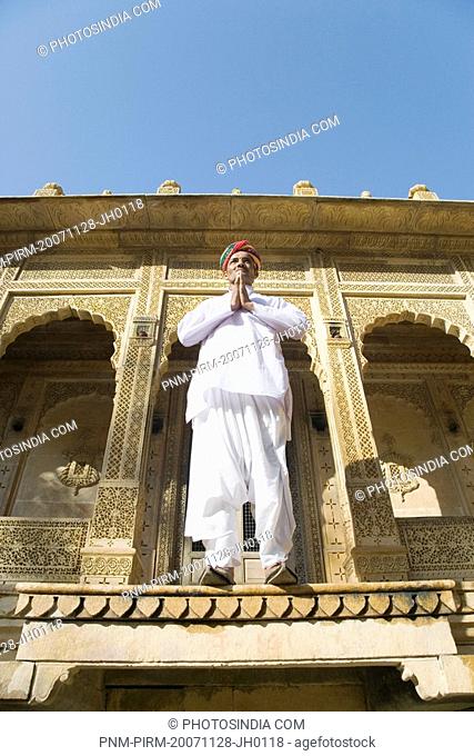 Mid adult man standing in front of a temple, Jaisalmer Fort, Jaisalmer, Rajasthan, India