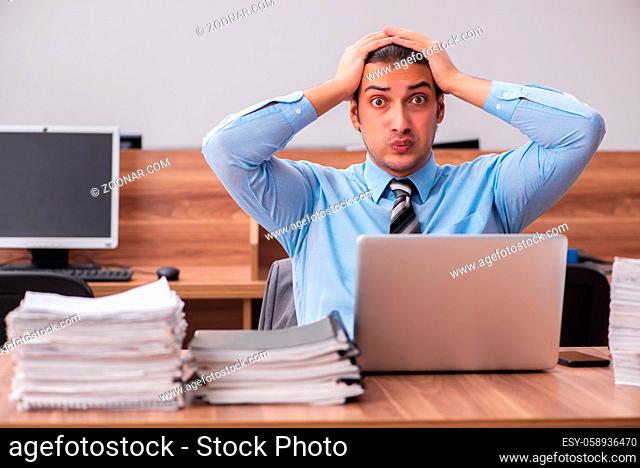 Young businessman employee unhappy with excessive work