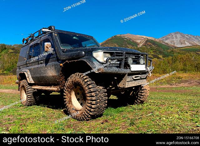 Toyota Land Cruiser Prado - extreme off-road expedition car on mountain forest landscape in autumn - popular travel destinations for climbing, hiking