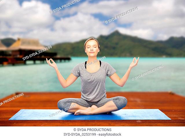 woman making yoga in and meditating lotus pose