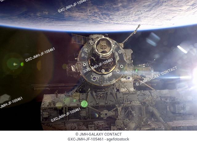 Backdropped by the blackness of space and Earth's horizon, this close-up view of the International Space Station (ISS) was photographed by a crewmember on board...