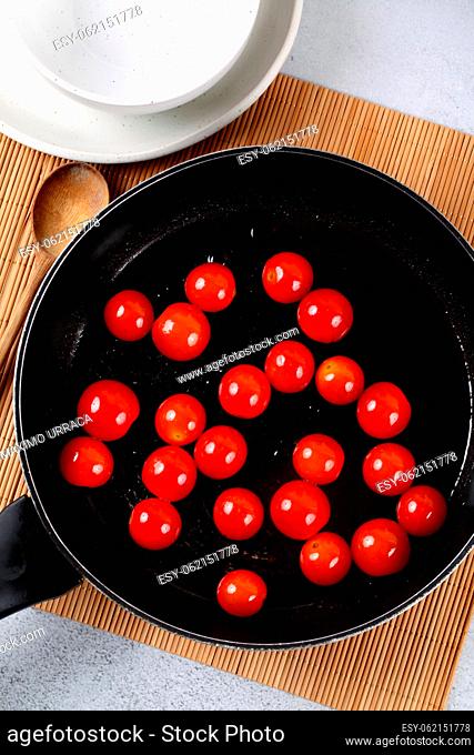 Skillet with hot cherry tomatoes