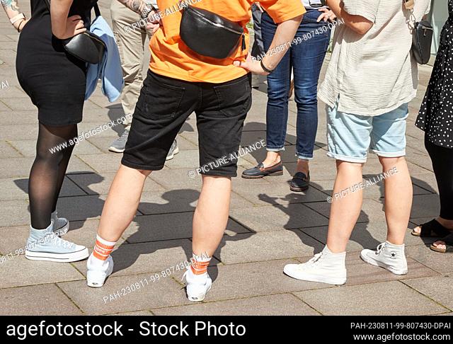 11 August 2023, Lower Saxony, Lüneburg: People are standing in a square in breezy clothes on this sunny and warm summer day. Photo: Georg Wendt/dpa