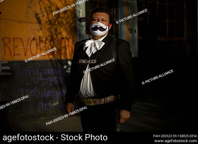 16 May 2020, Mexico, Mexiko-Stadt: Jose Fuentes, known as ""El bigotes"" (The Moustache), poses near Plaza Garibaldi and wears a mouthguard with a moustache...