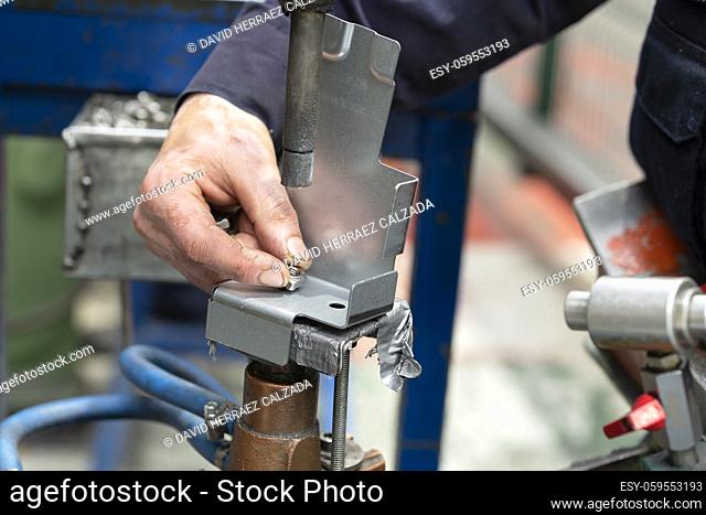Close up of a metal element being spot-welded by a factory worker. Industry concept