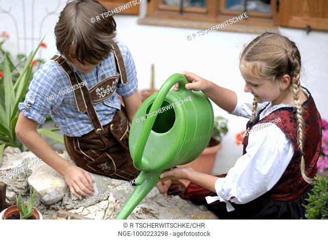 Girl and Boy in Costumes play at the Fountain, Bavaria
