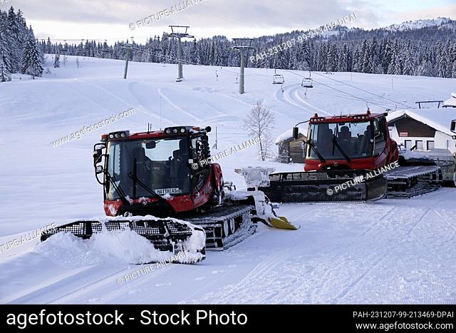07 December 2023, Bavaria, Reit im Winkl: Snow groomers on the Winklmoos-Alm. The ski area at around 1200 meters starts skiing on 09.12.2023