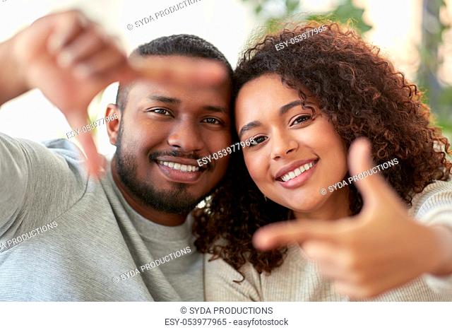 happy couple making selfie gesture at home