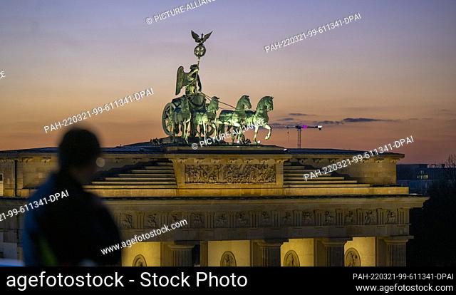18 March 2022, Berlin: The sky behind the Quadriga on the Brandenburg Gate turns colorful shortly after sunset. Photo: Monika Skolimowska/dpa