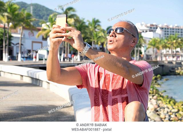 Mexico, Puerto Vallarta, tourist taking a selfie with smartphone
