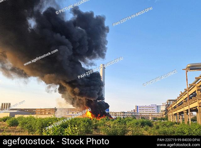 19 July 2022, Brandenburg, Premnitz: A cloud of black smoke rises above a chemical plant. In a warehouse of a chemical fiber producer in the Havelland district