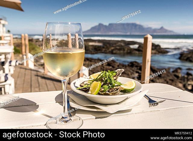 Weiswein und Austern vor Tafelberg von Bloubergstrand, Tafelberg und Kapstadt vom Bloubergstrand, Provinz Western Cape, Südafrika