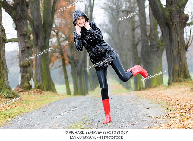 woman wearing rubber boots in autumnal alley