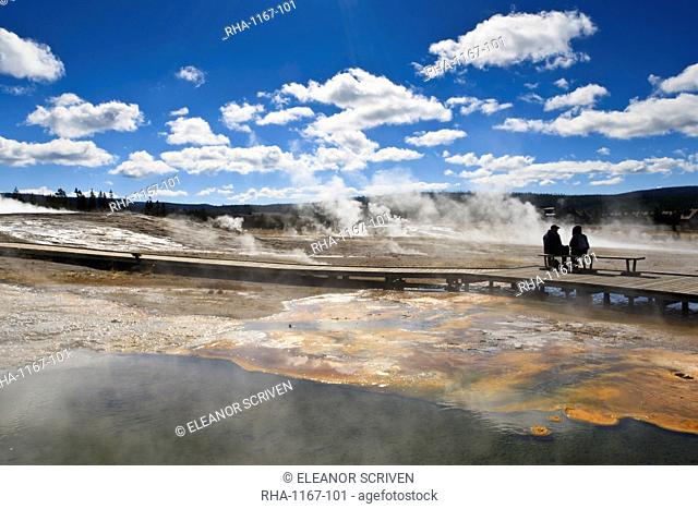 Cold tourists on seat surrounded by steam, Upper Geyser Basin, Yellowstone National Park, UNESCO World Heritage Site, Wyoming, United States of America