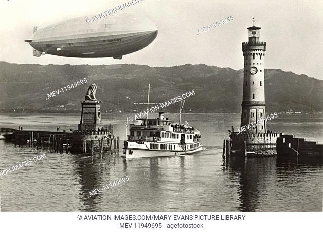 Zeppelin LZ-129 Hindenburg with Swastika Logo Flying Towards Lindau Harbour Entrance with a Lighthouse, Lion Statue and Boat