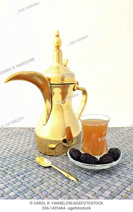 dallah Arabic coffee pot with cup of Arabic coffee and dates