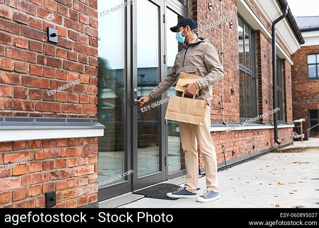 food delivery man in face mask with paper bags