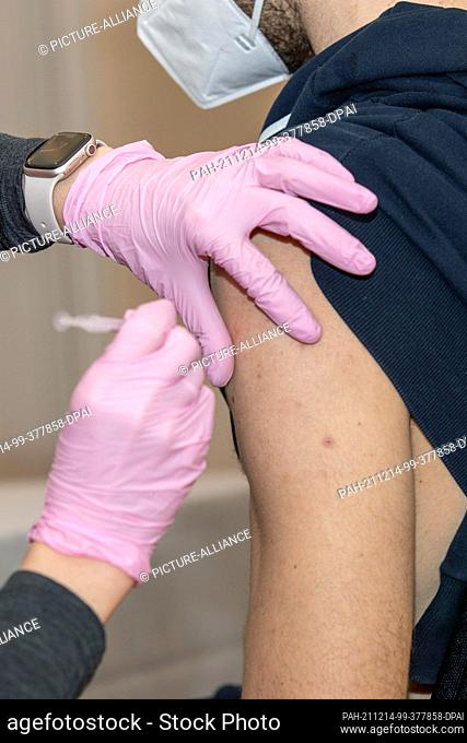 11 December 2021, Saxony, Dresden: A man is vaccinated by the Dresden doctor Catherina Jürgens in the 5-star Grand Hotel Taschenbergpalais