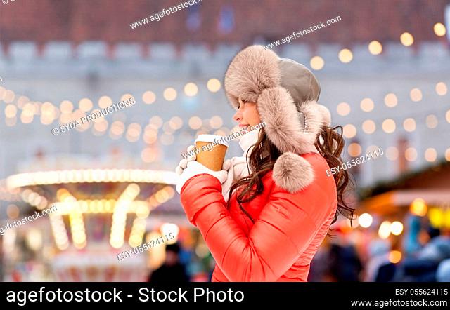 happy woman drinking coffee at christmas market