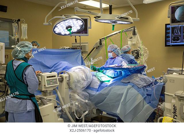 Englewood, Colorado - A surgical team prepares for minimally invasive lumbar spine surgery at Swedish Medical Center. A nurse injects a numbing agent
