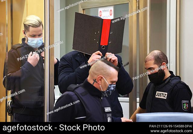 26 November 2021, North Rhine-Westphalia, Duesseldorf: The accused IS terrorist Nils D. (back, M) is led into the courtroom of the Higher Regional Court