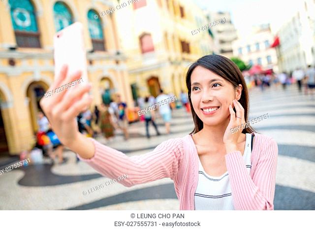 Young woman taking selfie in Macau city