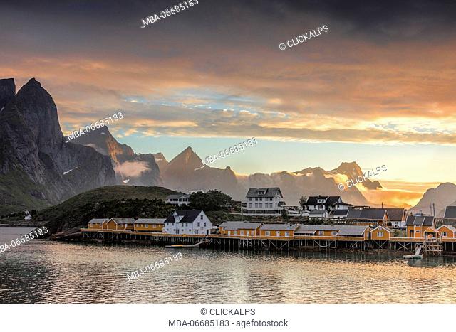 Sunset on the fishing village frames by rocky peaks and sea Sakrisoya Nordland county Lofoten Islands Northern Norway Europe