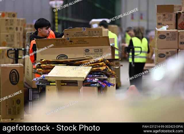 PRODUCTION - 14 December 2023, Bremen, Bremerhaven: Employees of Comet Feuerwerk GmbH, a pyrotechnics company, prepare boxes of fireworks for New Year's Eve in...