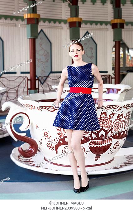 Woman in spotty dress standing near merry go round