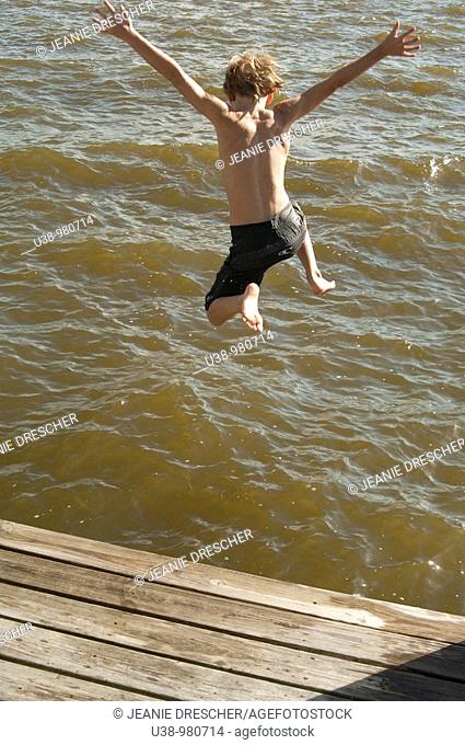 Boy jumping from boat dock into the Albemarle Sound
