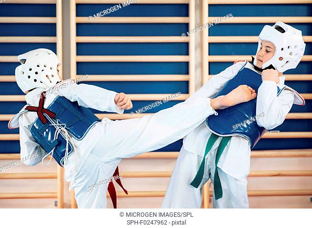 Two kids sparing in taekwondo class