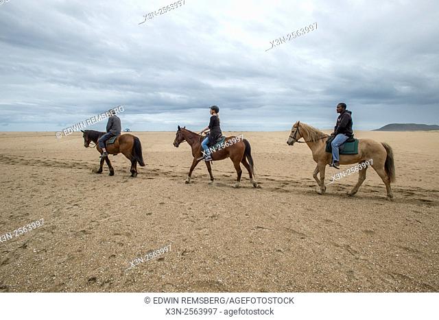 Tourists riding horses on the beach in Saint Lucia, Kwazulu-Natal, South Africa - iSimangaliso Wetland Park