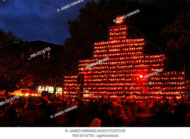 Hundreds of pumpkins are lit at night, concluding a large pumpkin festival