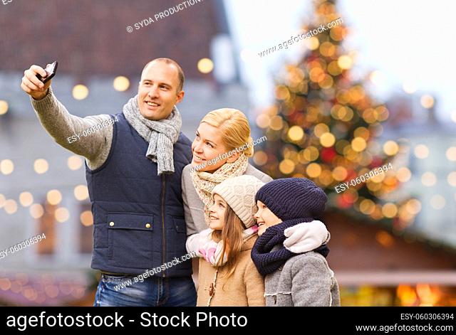 happy family taking selfie at christmas market
