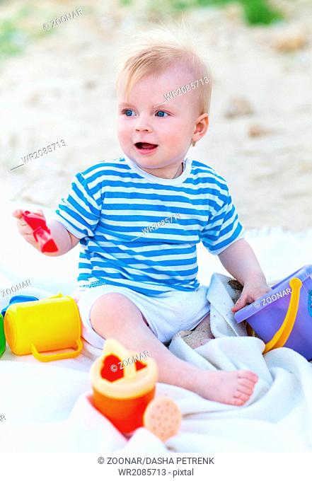 Baby girl playing with beach toys on the beach