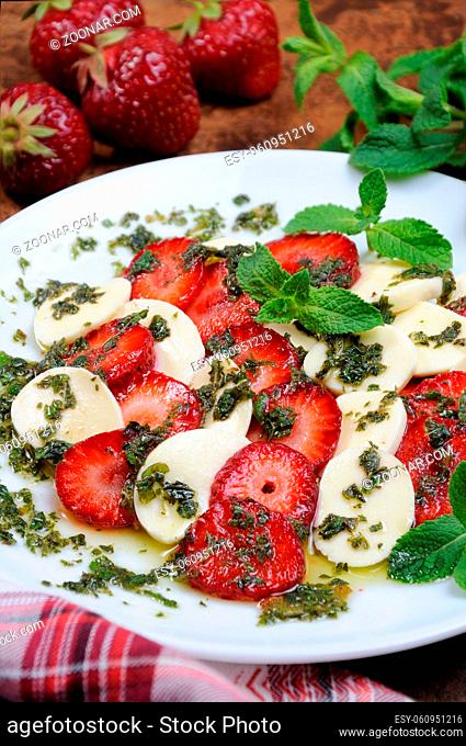 Light snack caprese with strawberries and mozzarella dressed  mint pesto