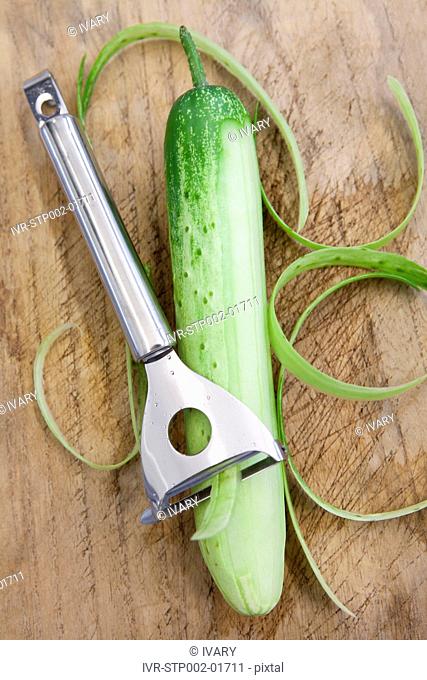 Cucumber And Peeler On Chopping Board