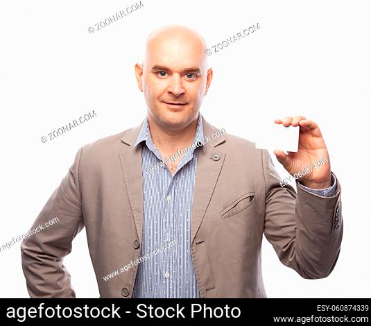 A bald man in a beige suit shows a business card. Free space for design or lettering. Isolated on a white background