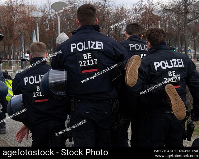 13 April 2021, Berlin: Police officers lead away a demonstrator in the government quarter who was protesting against the tightening of the infection protection...