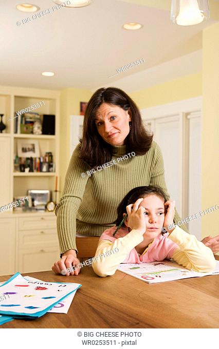 Mom with bored daughter doing homework